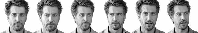 A man with swept-back hair and stubble